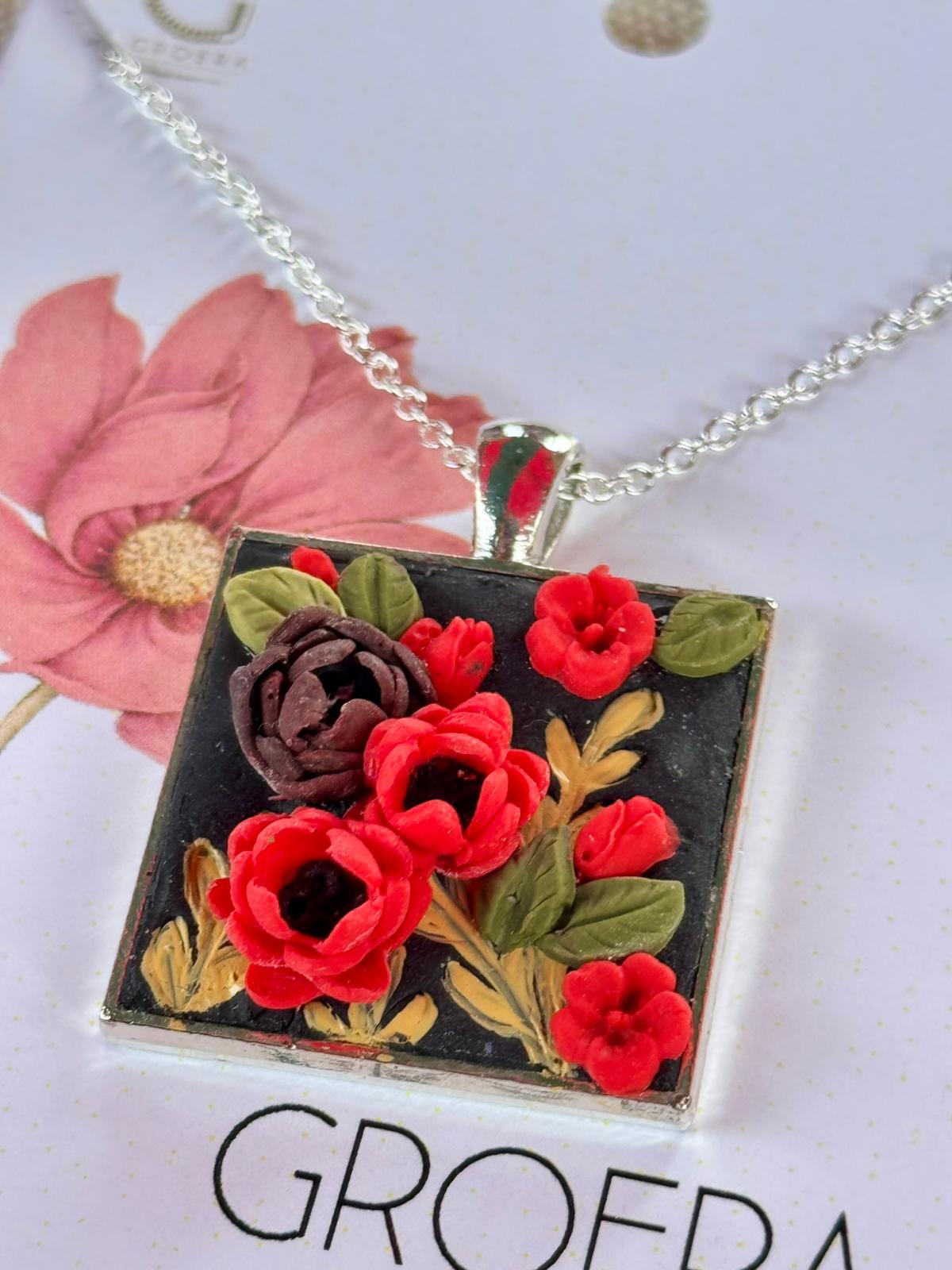 Necklace with a square pendant featuring red flowers on a white background