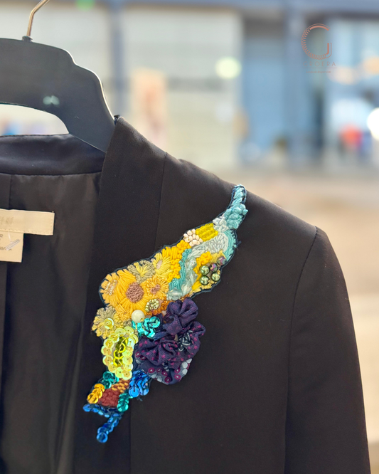 Colorful floral embroidery on a black garment with a blurred background