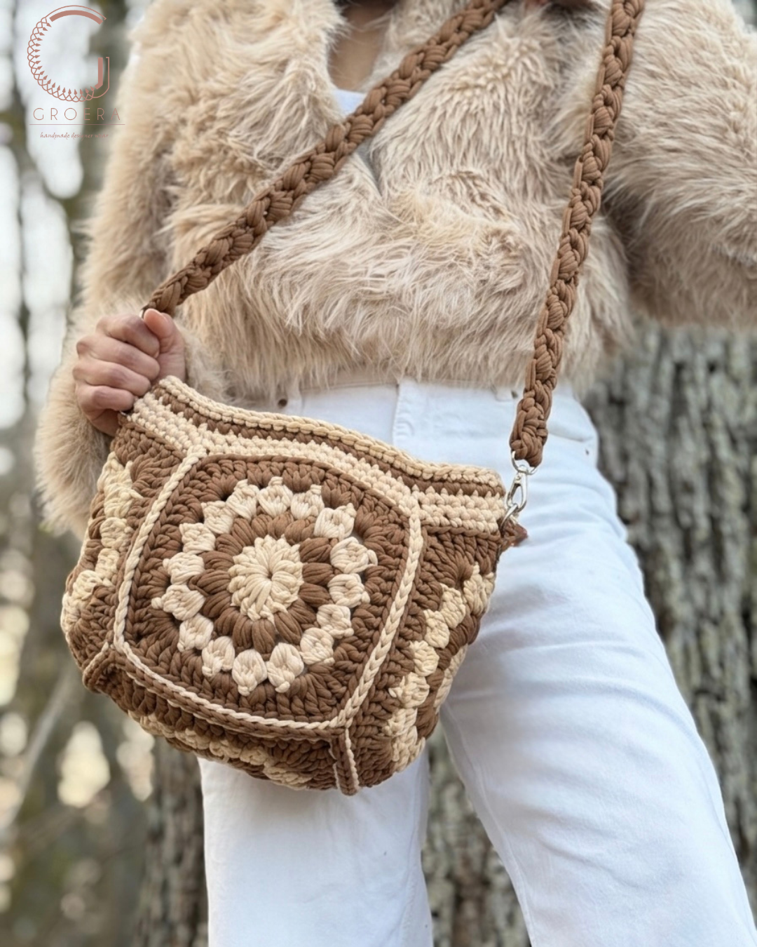 Person holding a brown and beige crochet bag with a blurred natural background