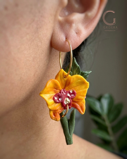 Floral earring worn by a person with a blurred background
