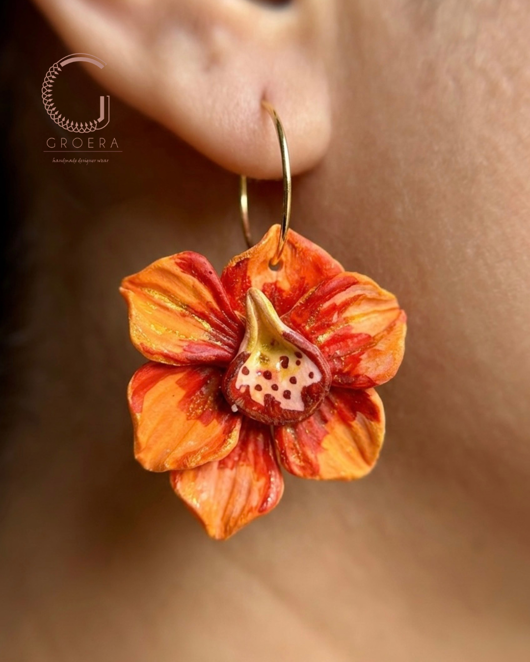 Floral earring worn on an ear with a blurred background