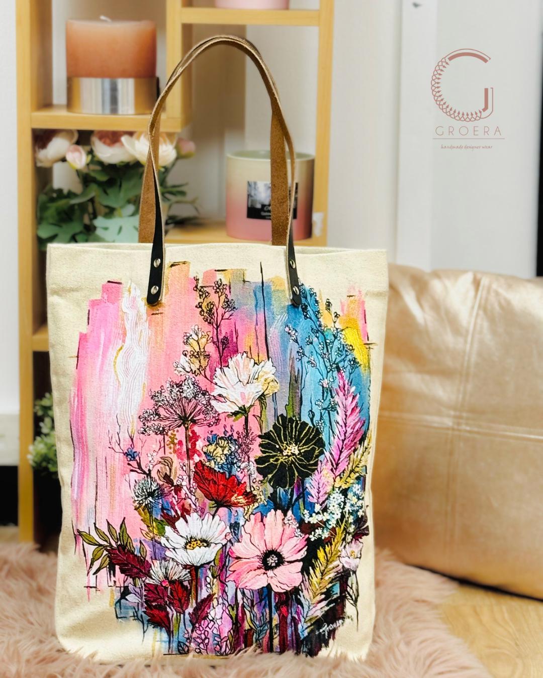 Floral tote bag with colorful design on a surface with a blurred background