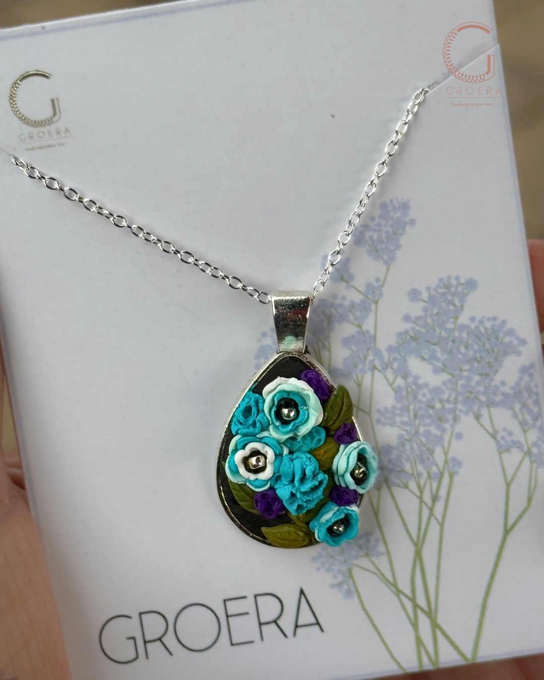 Necklace with a floral pendant on a Groera branded card
