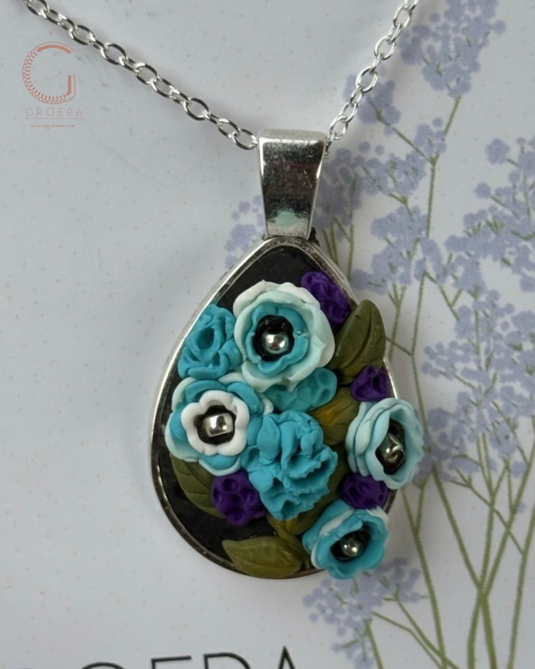 Floral pendant necklace with blue flowers on a white background