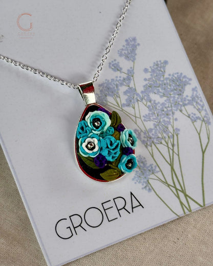 Necklace with floral pendant on a card featuring the brand 'GROERA'.