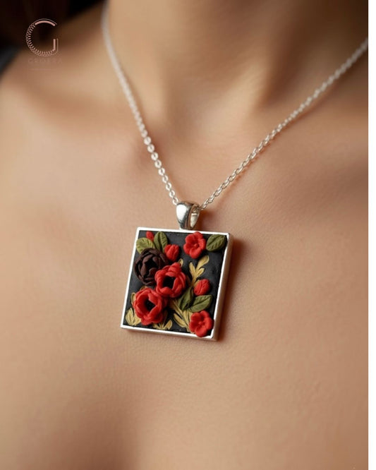 Necklace with a square pendant featuring red flowers on a plain background